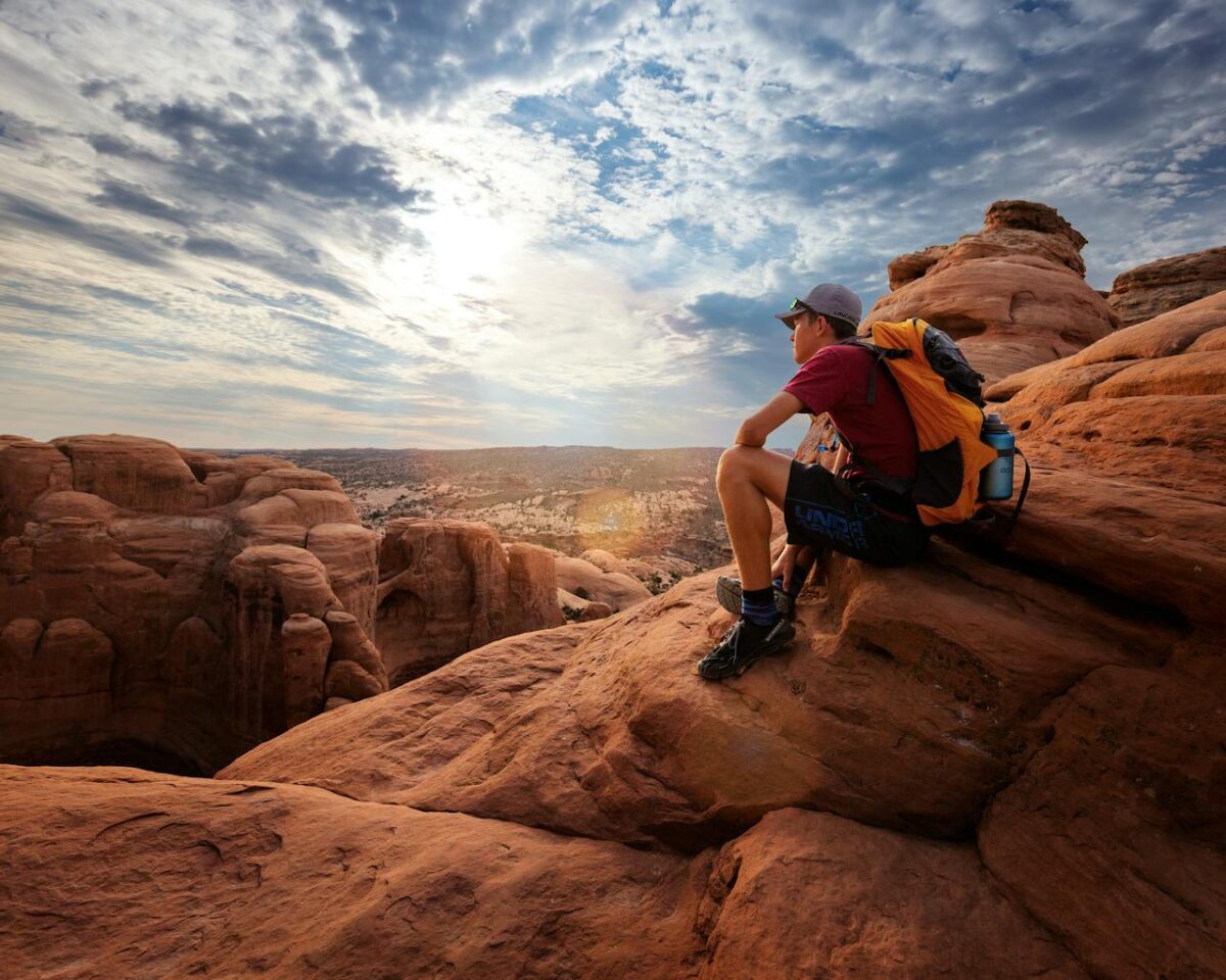 Backpacker enjoying the stunning rock formations in Moab, Utah at sunrise.
